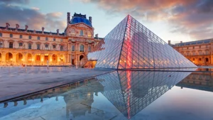 A group of visitors attentively listening to a private guide in the Louvre Museum, with famous artworks in the background, organized by Seamless Holidays for a personalized and enriching experience.